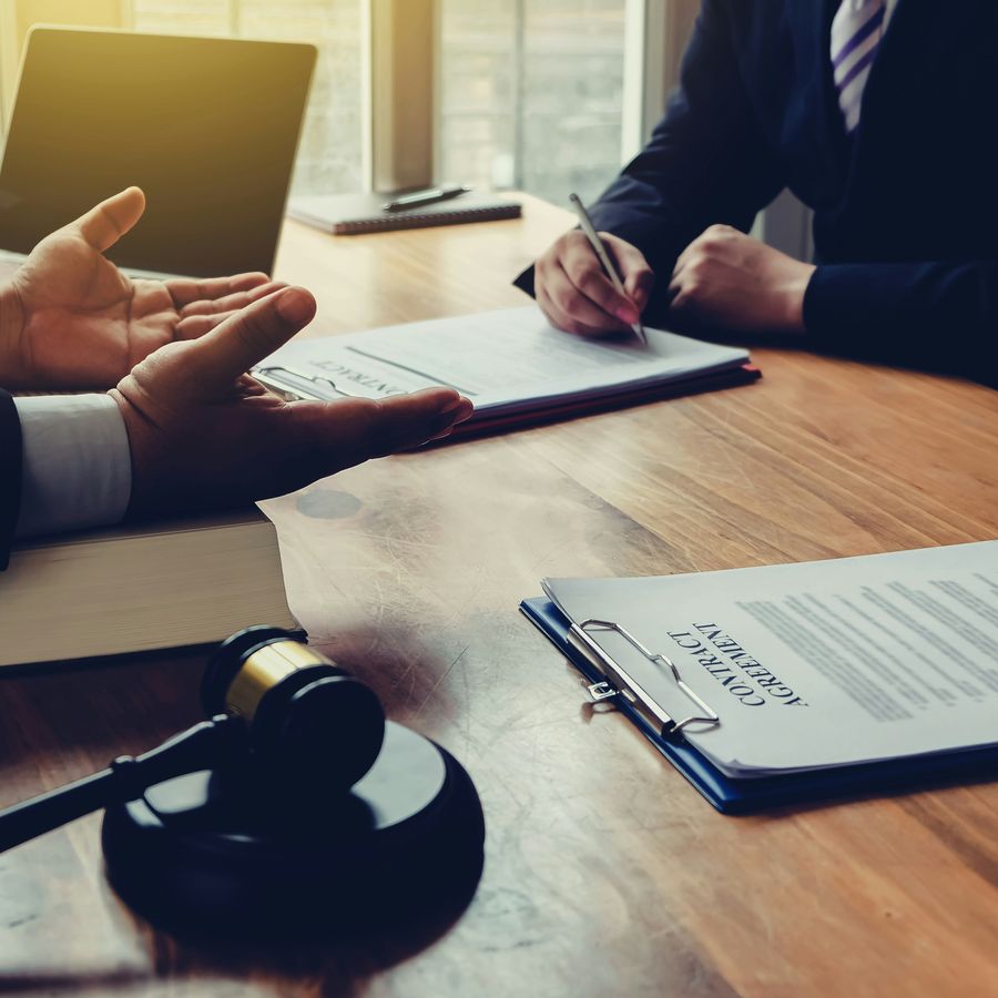 Un professionnel prépare son mémoire de frais de justice à son bureau, documents de procédure et signature à l'appui.